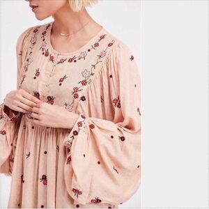Free People Kiss From a Rose Tunic Top in a light pink/peach color.